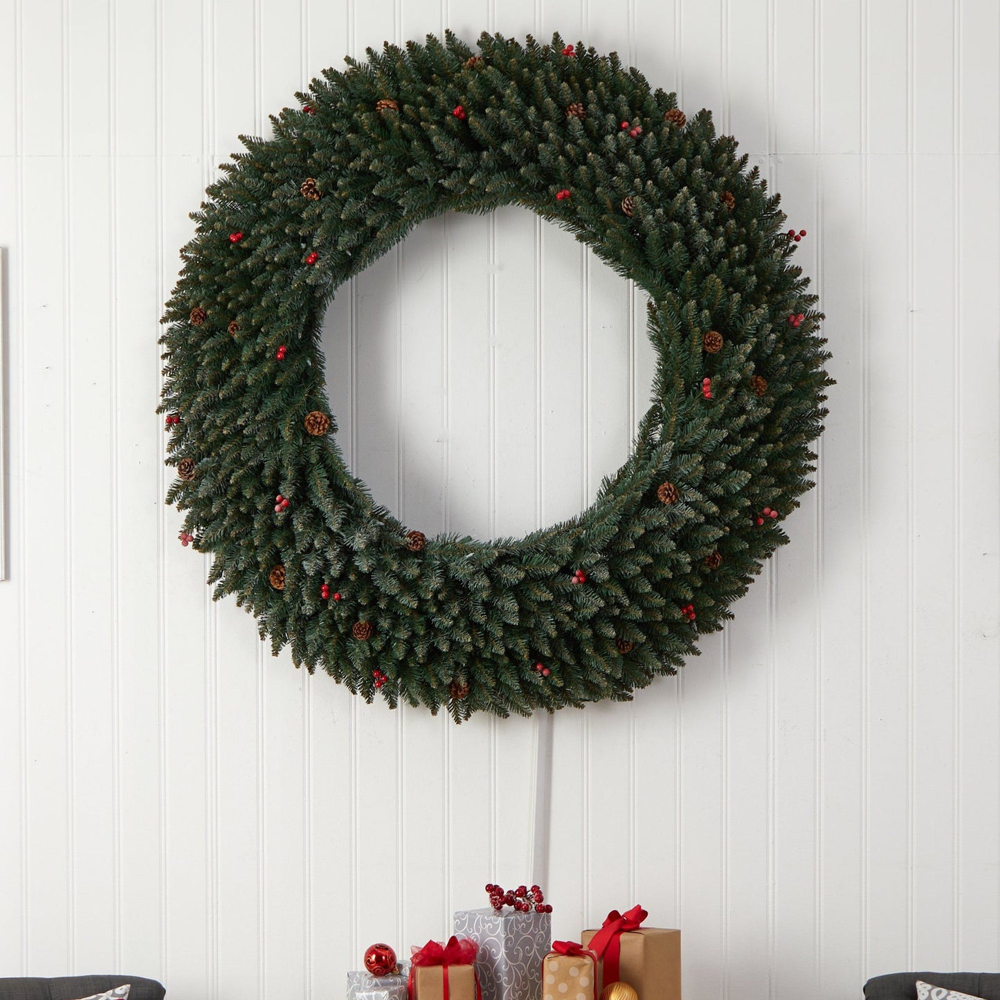 5 ft large green flocked wreath with pinecones and red berries on white paneled wall on Tampa Home & Garden Store
