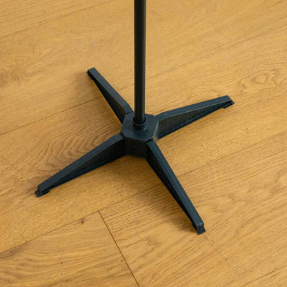 Black cross-legged Christmas tree stand with central pole on wooden floor on Tampa Home & Garden Store