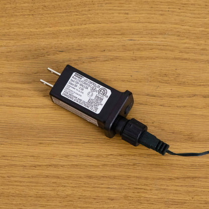 LED controller for a pre-lit Christmas tree; black power adapter with label and two-pin plug on Tampa Home & Garden Store
