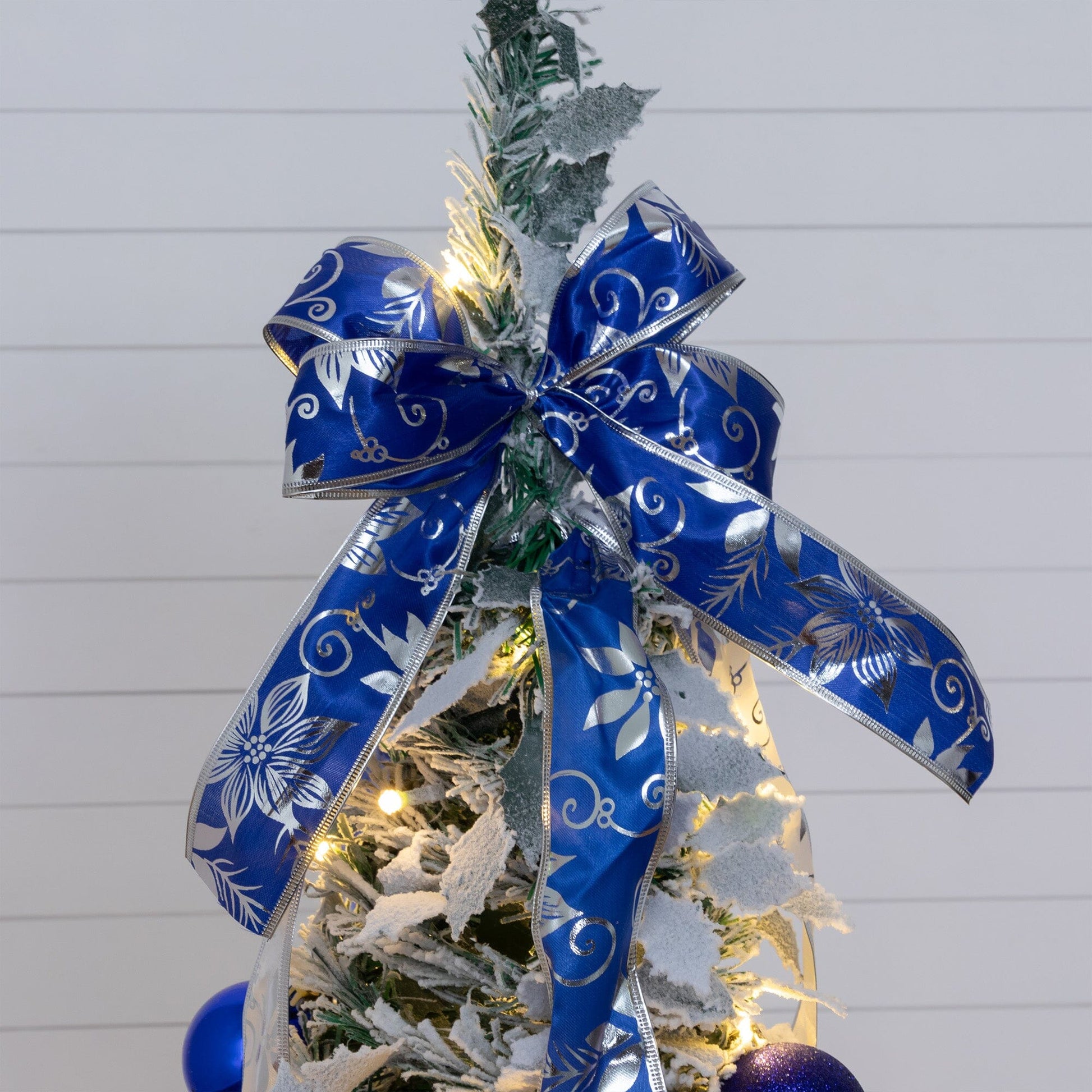 5' pre-lit flocked Christmas tree with blue ribbon and blue ornaments, white LED lights on Tampa Home & Garden Store