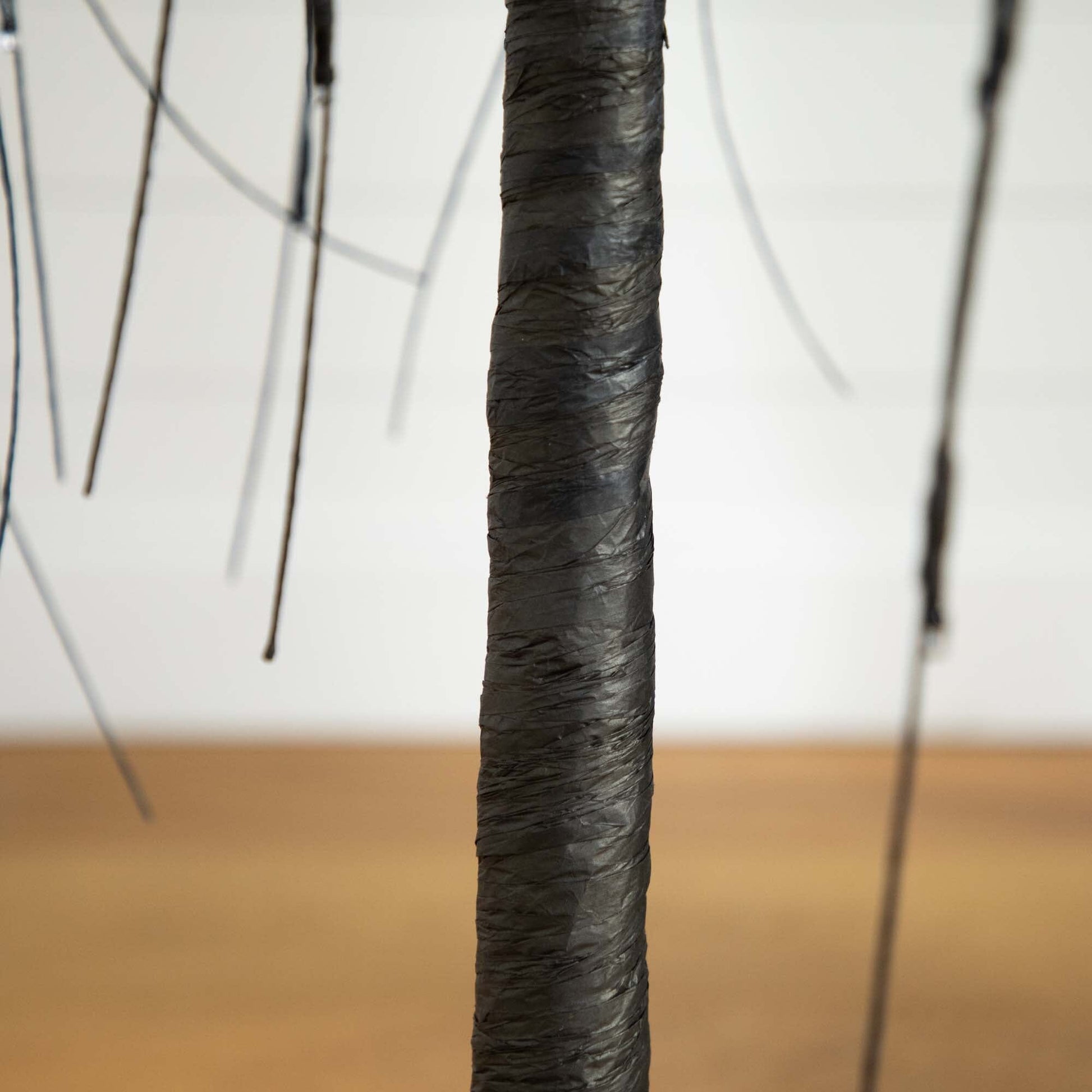 Tree trunk close-up of a 5 ft Halloween black willow artificial tree wrapped in black material on Tampa Home & Garden Store