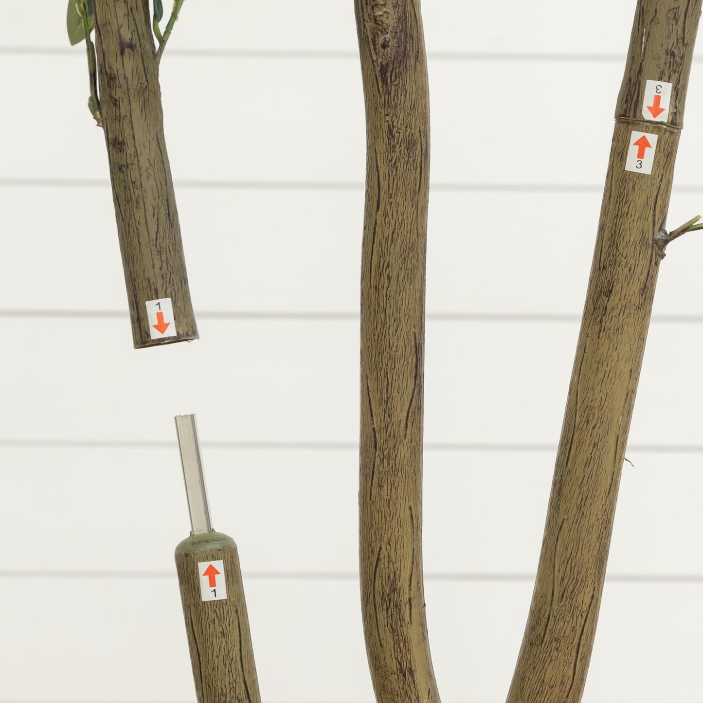 Artificial olive tree with brown bark trunks, three stems and small green leaves; display stickers on limbs on Tampa Home & Garden Store
