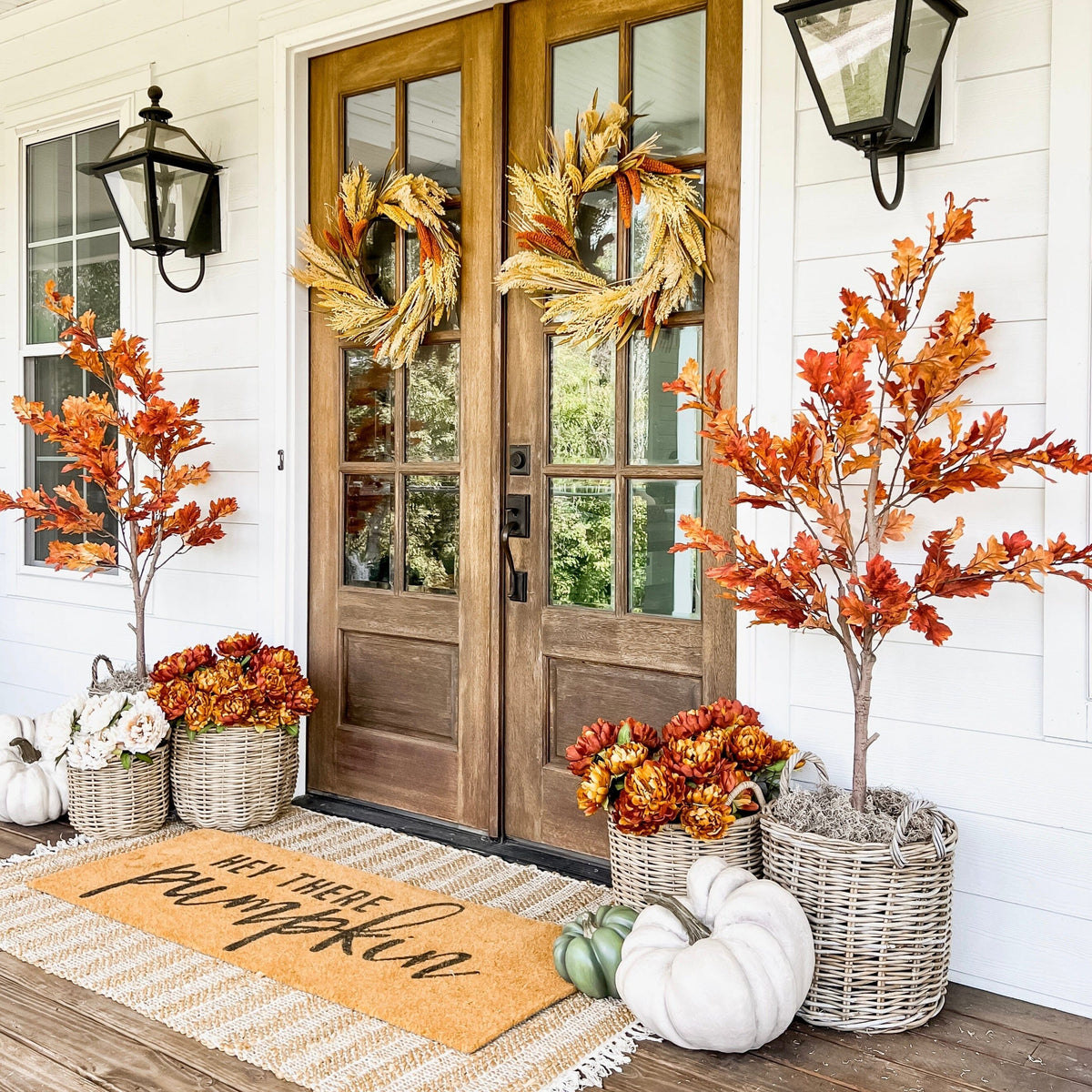 6’ Autumn Oak Artificial Fall Tree with orange foliage by Nearly Natural beside a wooden front door on Tampa Home & Garden Store