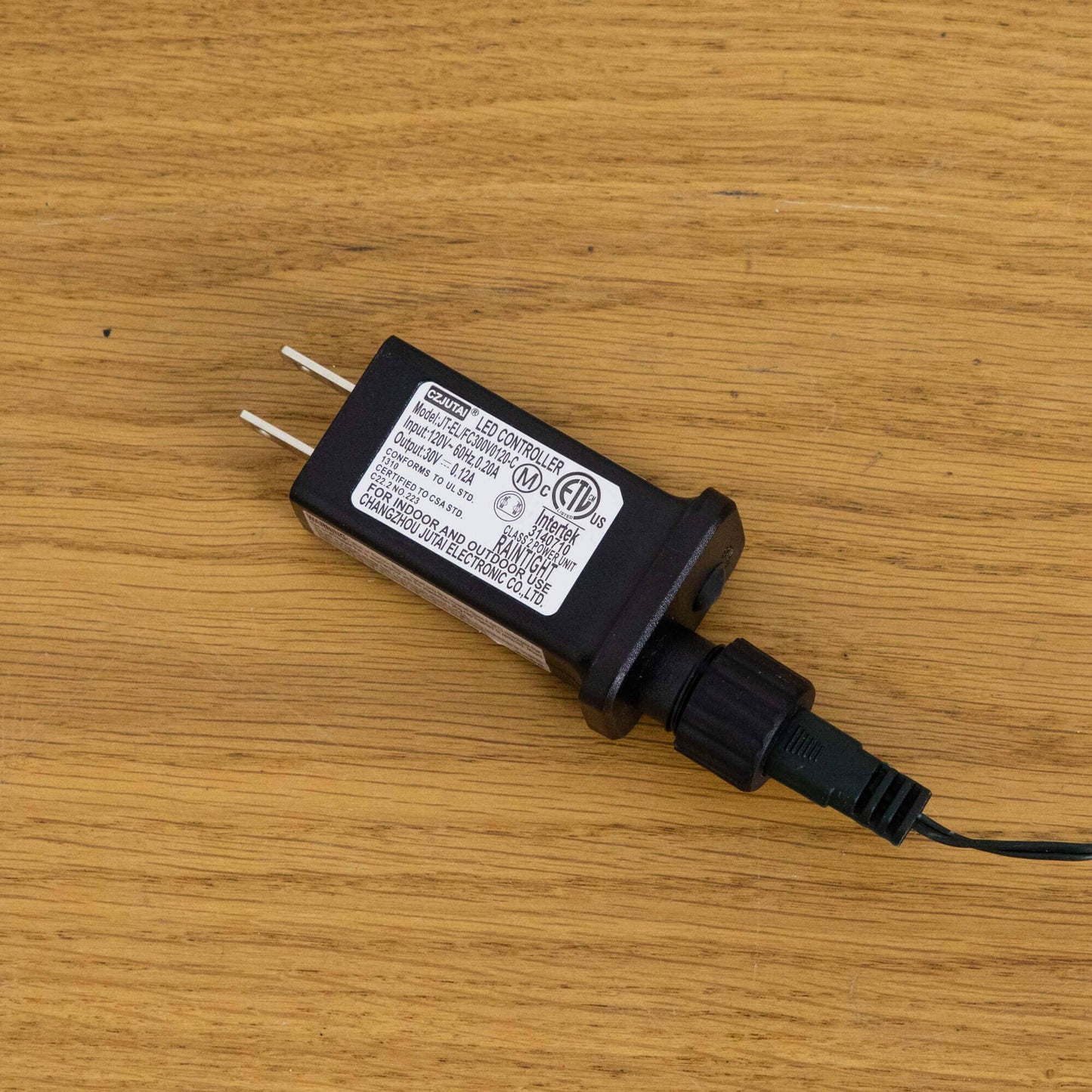 Black LED controller for Christmas lights with white label on wood surface on Tampa Home & Garden Store