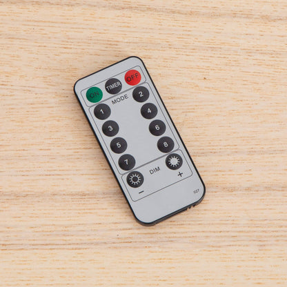 Remote control with many black buttons placed on light wood surface on Tampa Home & Garden Store