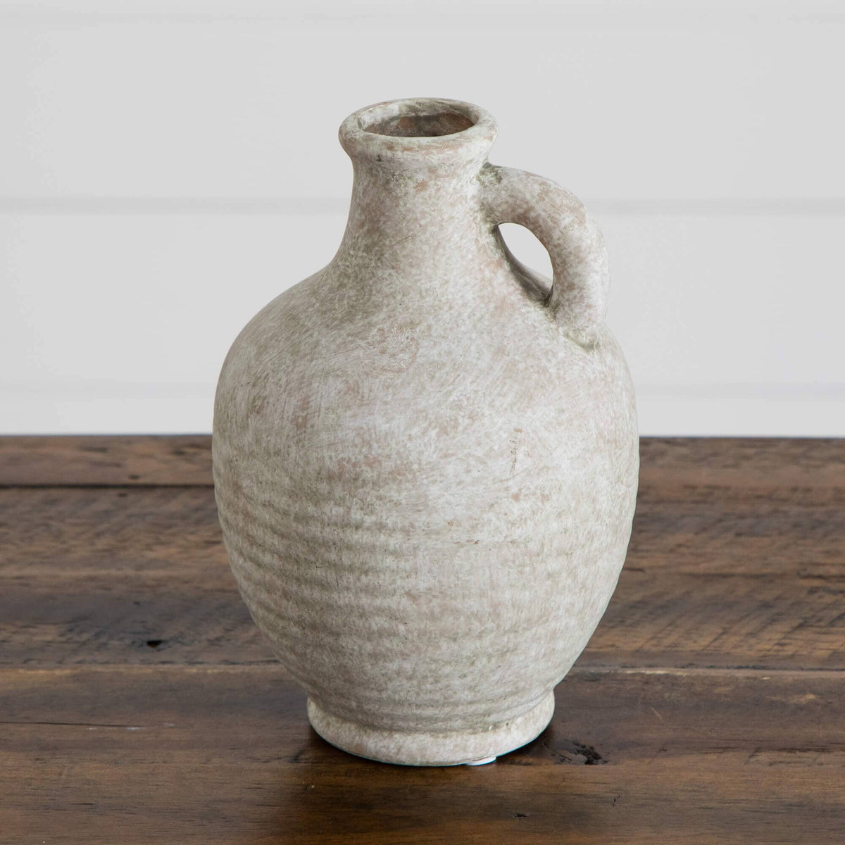 7-inch natural ceramic jug vase with weathered beige glaze and curved handle on a wooden surface on Tampa Home & Garden Store