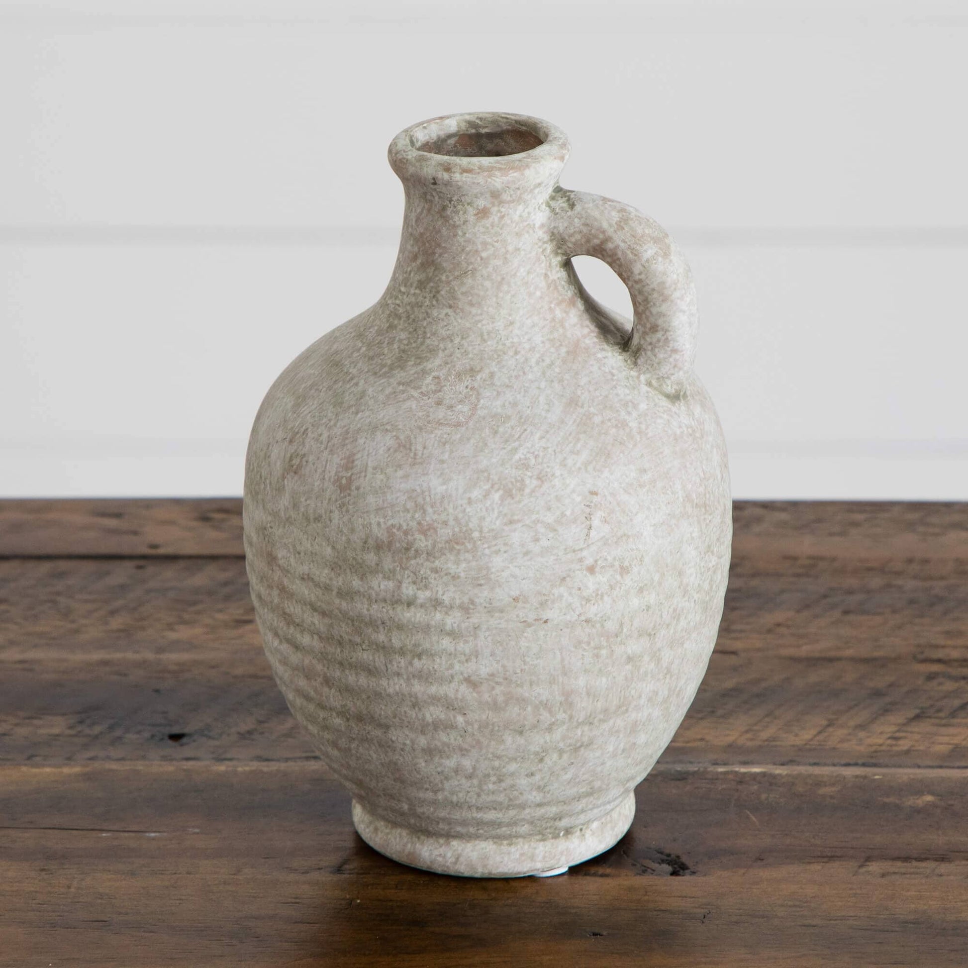 7-inch natural ceramic jug vase with weathered beige glaze and curved handle on a wooden surface on Tampa Home & Garden Store