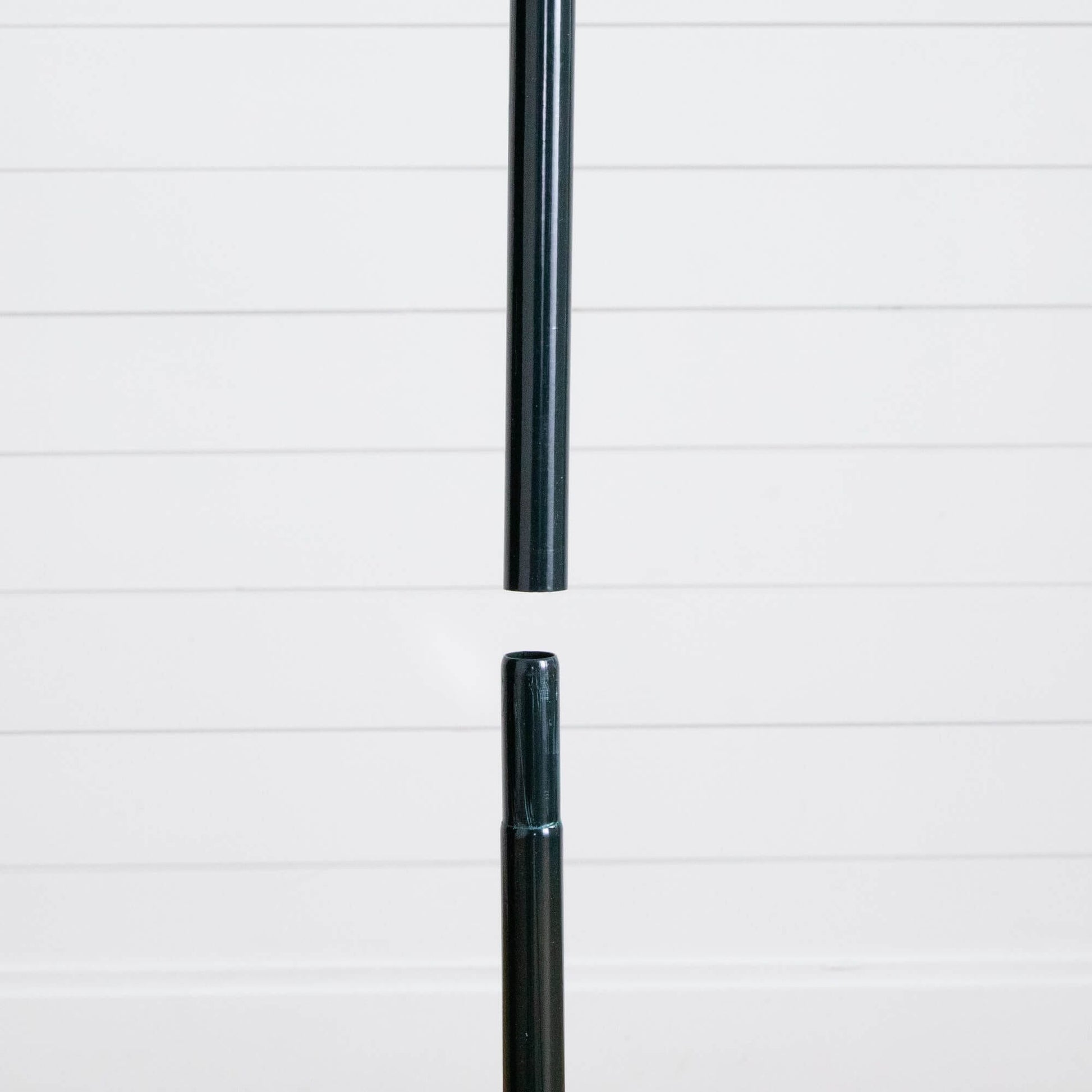 Christmas tree stand pole, black metal, shown against white shiplap backdrop on Tampa Home & Garden Store