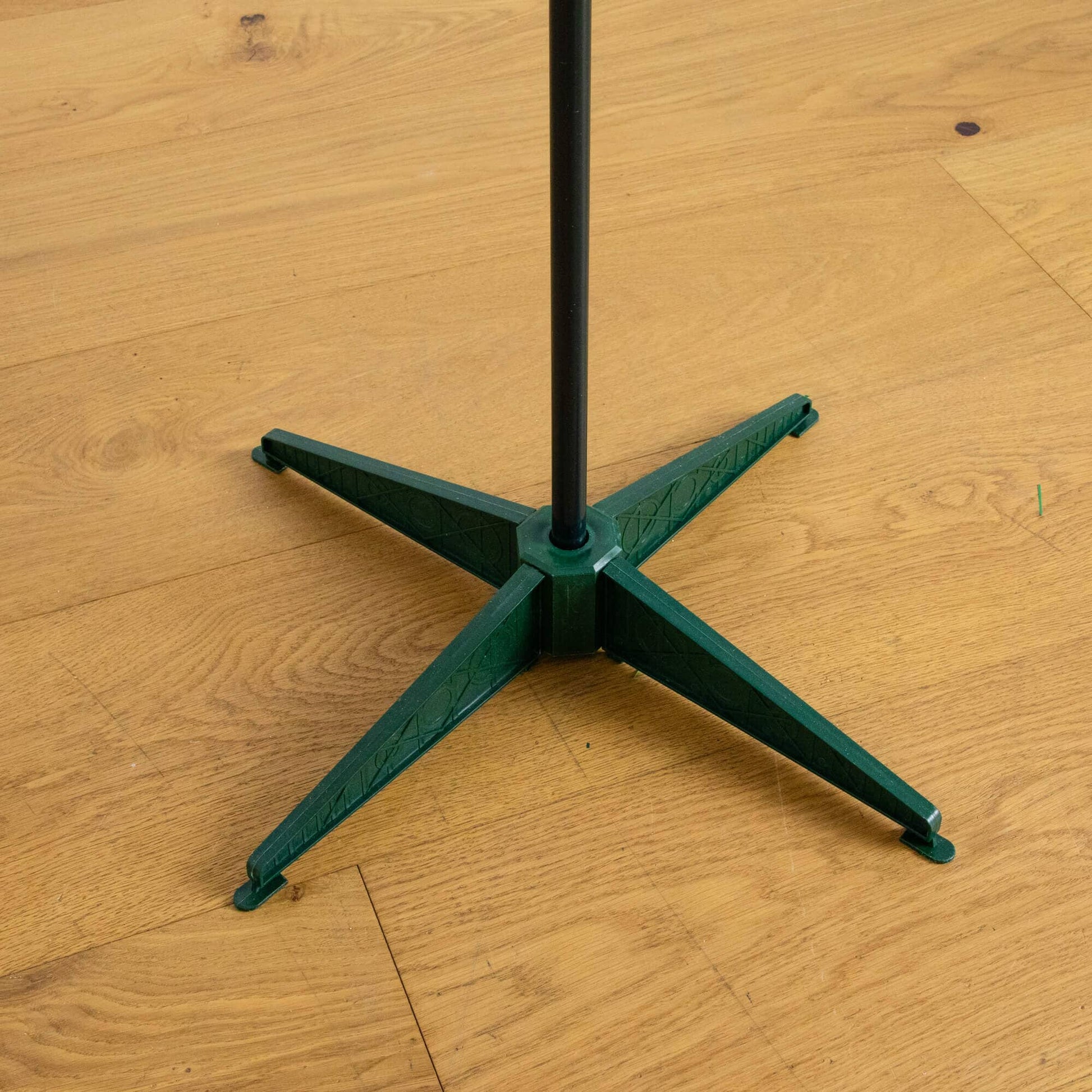 Nearly Natural Christmas tree stand with black central pole and green cross base on Tampa Home & Garden Store