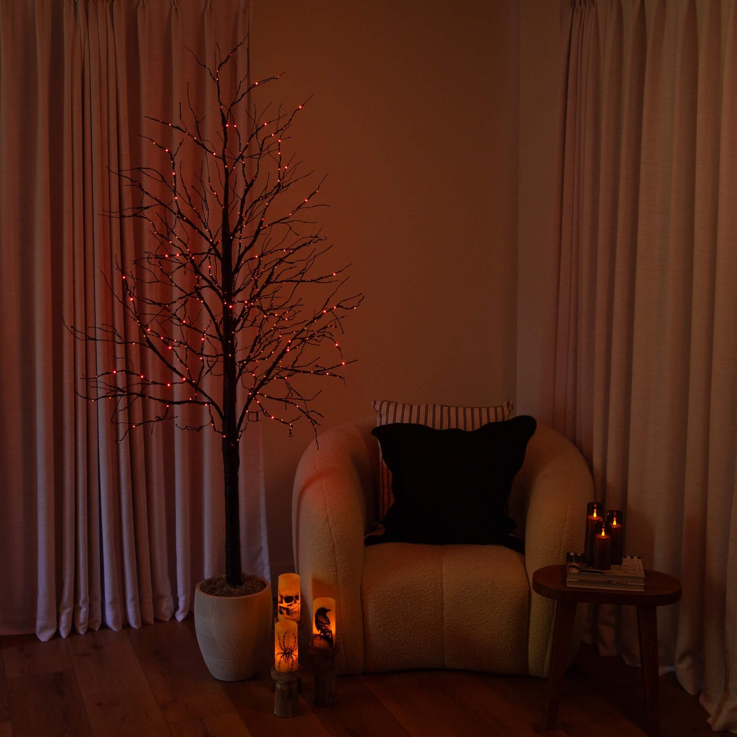 7' Pre-Lit Halloween Black Twig Tree with orange and purple LEDs in a white pot beside sofa on Tampa Home & Garden Store