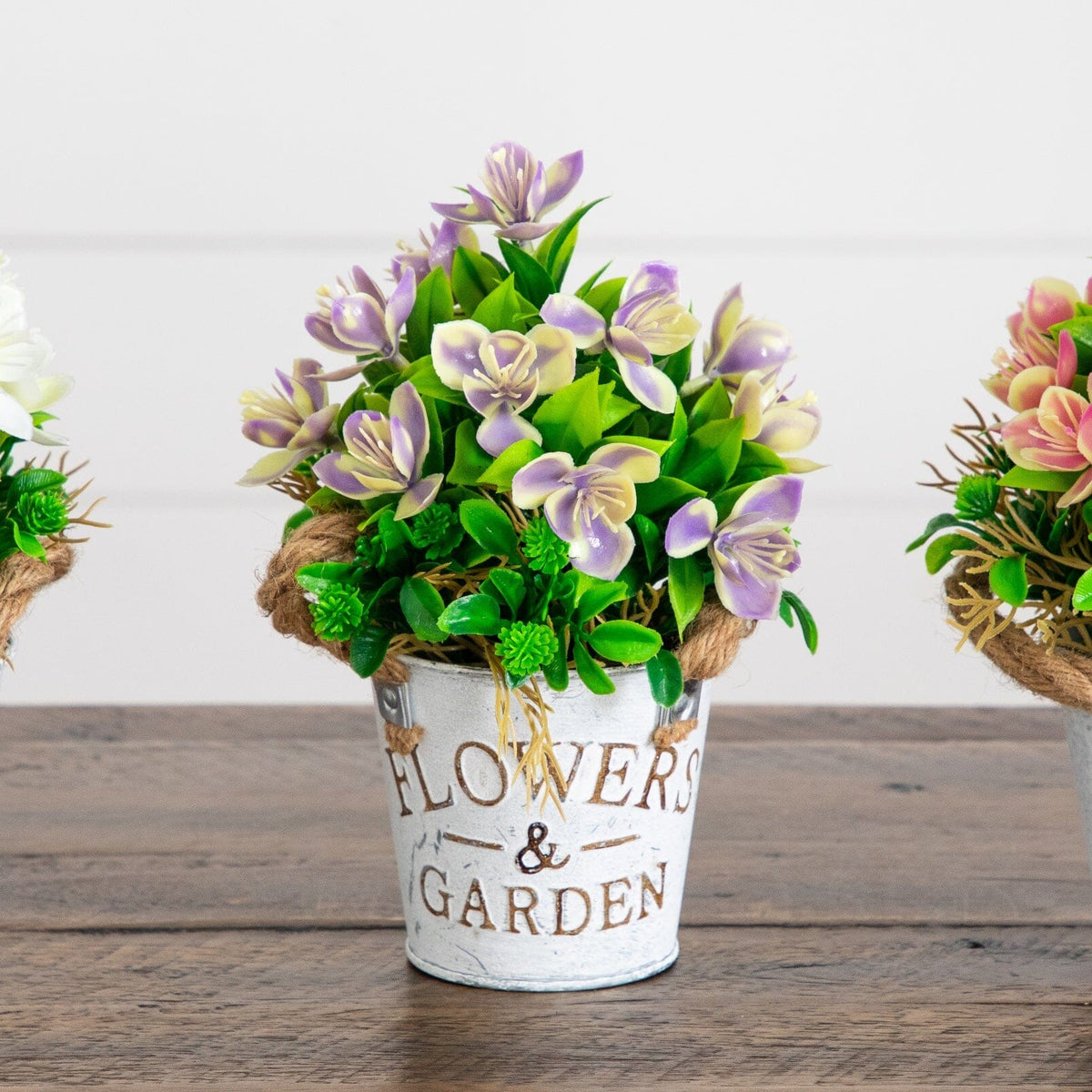 8-inch artificial flowering plant trio with purple cream blossoms in rustic metal planter bucket on Tampa Home & Garden Store