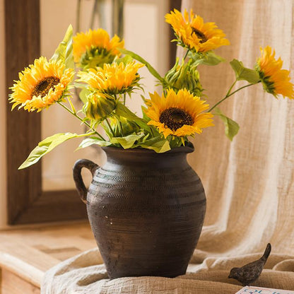 Faux Silk Sunflower stems in a dark ceramic vase with bright yellow blooms and green leaves on Tampa Home & Garden Store