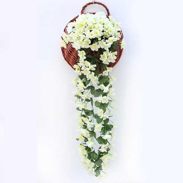 Artificial wisteria hanging basket with cream flowers and green leaves in a brown wicker basket on Tampa Home & Garden Store