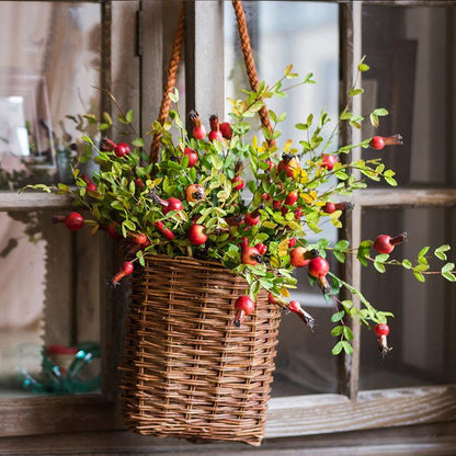 Artificial pomegranate fruit stem with red berries and green foliage in a woven hanging basket on Tampa Home & Garden Store