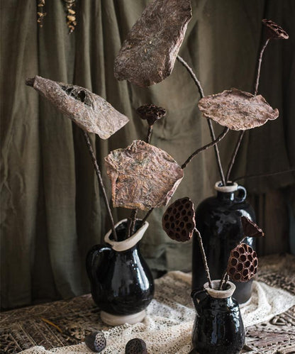 Artificial dried lotus leaf and pod stems by RusticReach arranged in black ceramic vases on Tampa Home & Garden Store