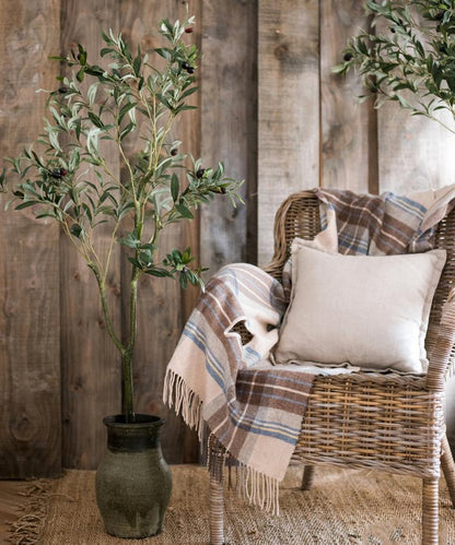 Artificial Silk Faux Olive Tree In Pot with olive leaves in ceramic pot next to wicker chair on Tampa Home & Garden Store