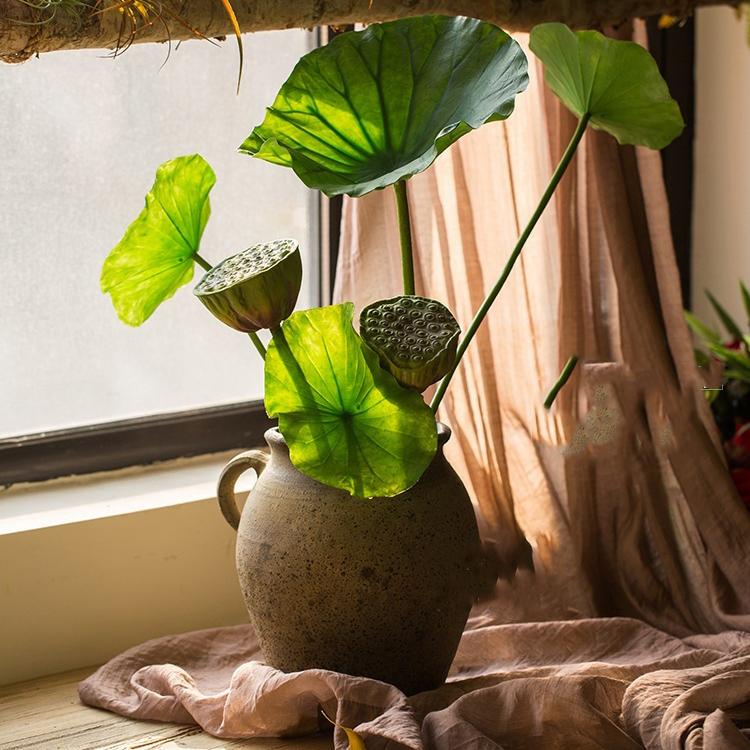 Artificial lotus seed and leaf stem arrangement in a ceramic vase with leaves in varied sizes on Tampa Home & Garden Store