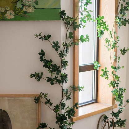 Artificial Vine Schefflera Leaf by RusticReach; green faux vines drape around a wooden window frame on Tampa Home & Garden Store