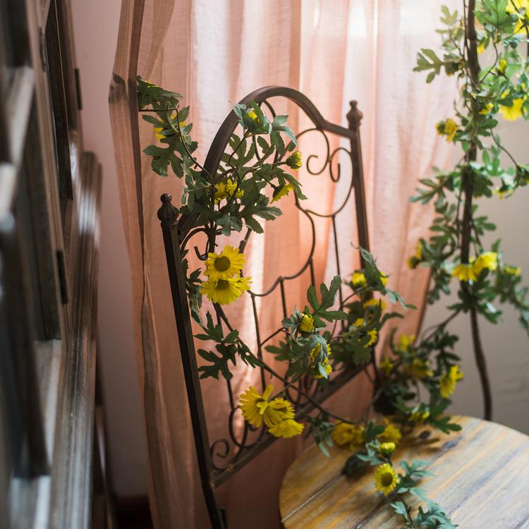 Artificial Sunflower Vine with yellow blooms and green leaves on RusticReach wrought-iron trellis on Tampa Home & Garden Store