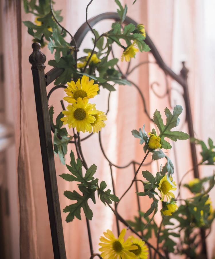 Artificial Sunflower Vine 67 in long by RusticReach, yellow blooms on black metal trellis on Tampa Home & Garden Store
