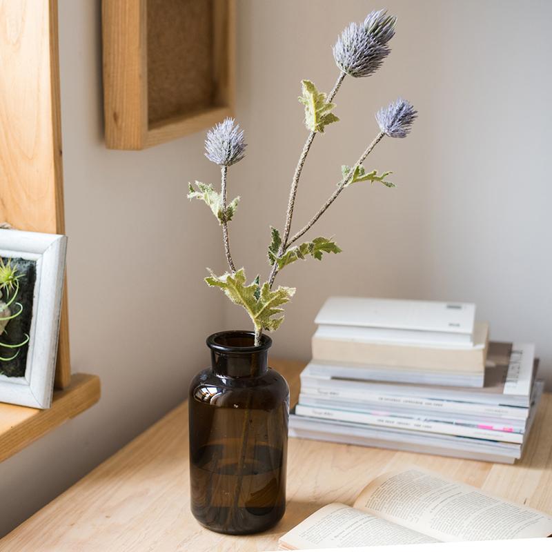 Faux Silk Thistle Flower Stem 26-inch tall in a dark glass vase with blue blooms and green leaves on Tampa Home & Garden Store