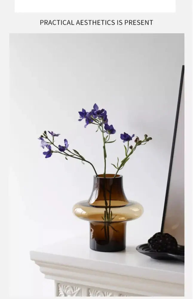 Amber glass bulbous vase by Decorbites with purple flowers on a white mantel on Tampa Home & Garden Store