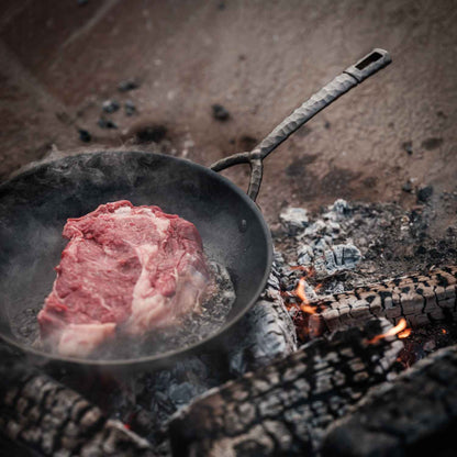 Carbon Steel Frying Pan by Alva Cookware with hammered handle cooking steak over open flame on Tampa Home & Garden Store
