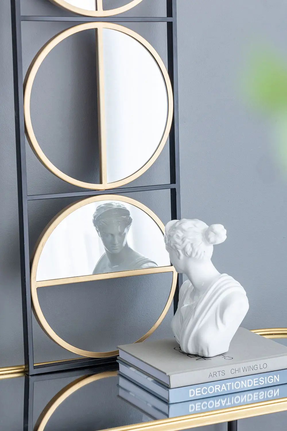 Accent mirrors: stacked circular gold-rim panels in a black metal frame; white bust beside on Tampa Home & Garden Store
