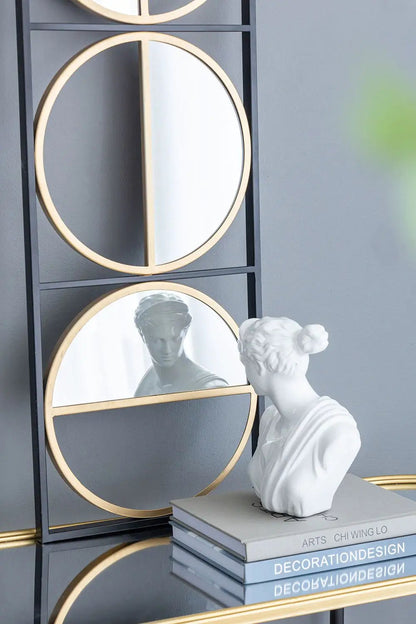 Accent mirrors: stacked circular gold-rim panels in a black metal frame; white bust beside on Tampa Home & Garden Store