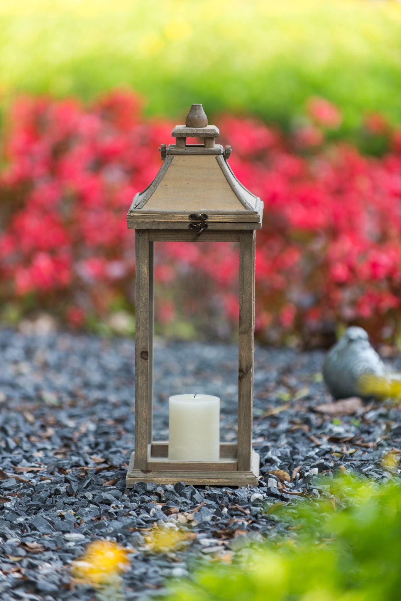 Ivory hurricane lantern by HouseOfZazla with glass panels and candle inside in garden setting on Tampa Home & Garden Store
