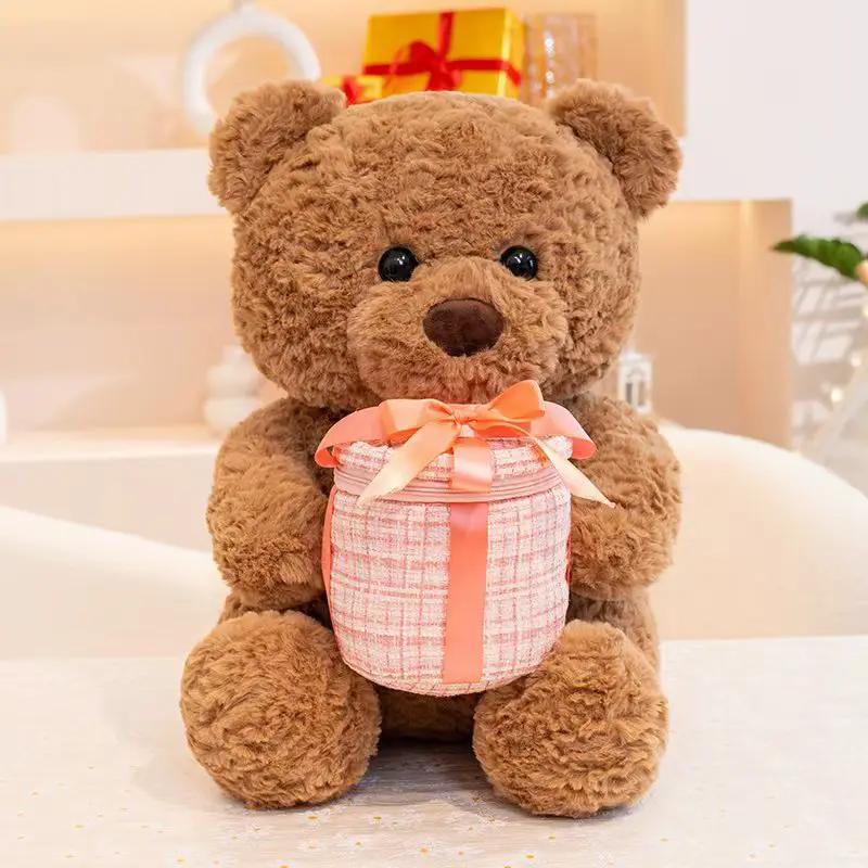 Brown plush teddy bear holding a pink checkered gift box with a peach satin ribbon on Tampa Home & Garden Store