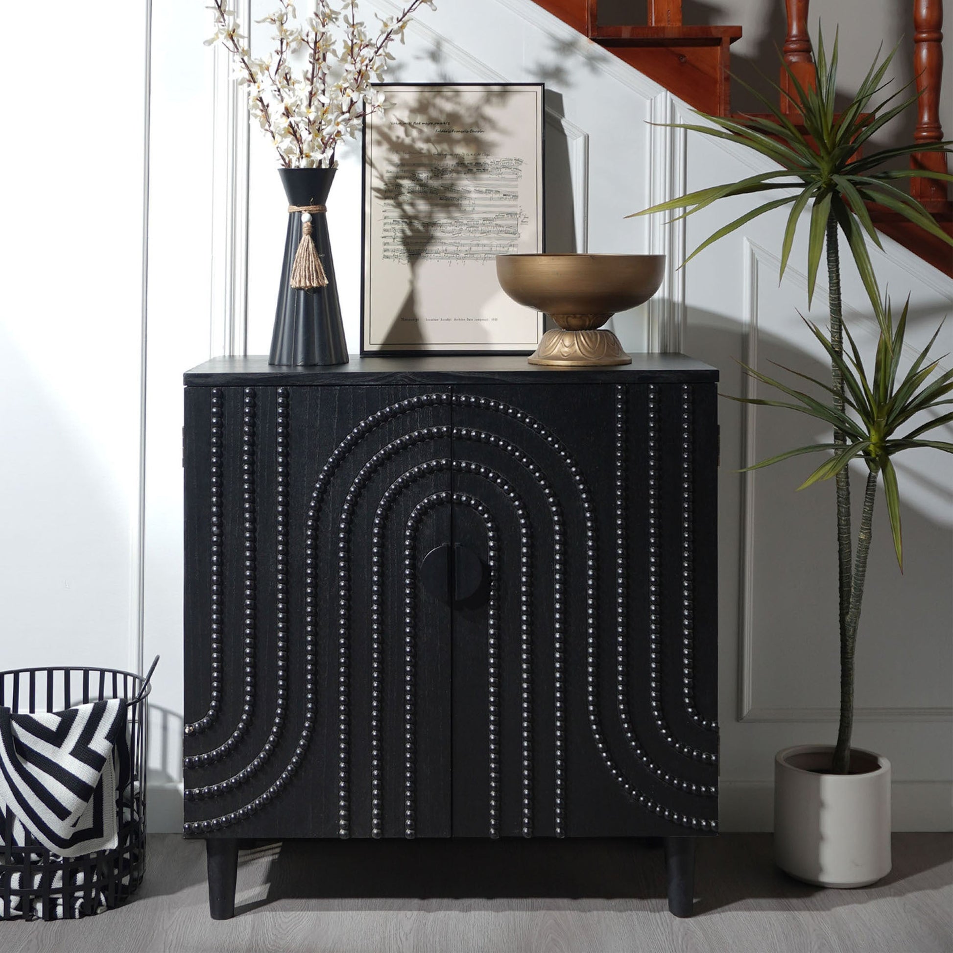 Modern black wood storage cabinet with decorative door; features studded circular panels on Tampa Home & Garden Store