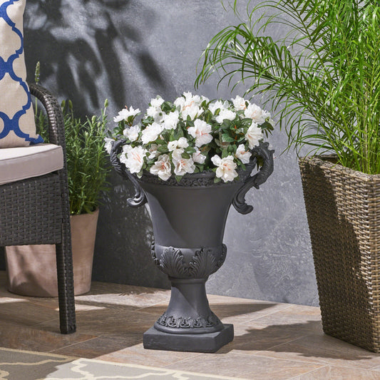 Delphine Urn Planter, black ornate pedestal with scroll handles and white blooming flowers on Tampa Home & Garden Store