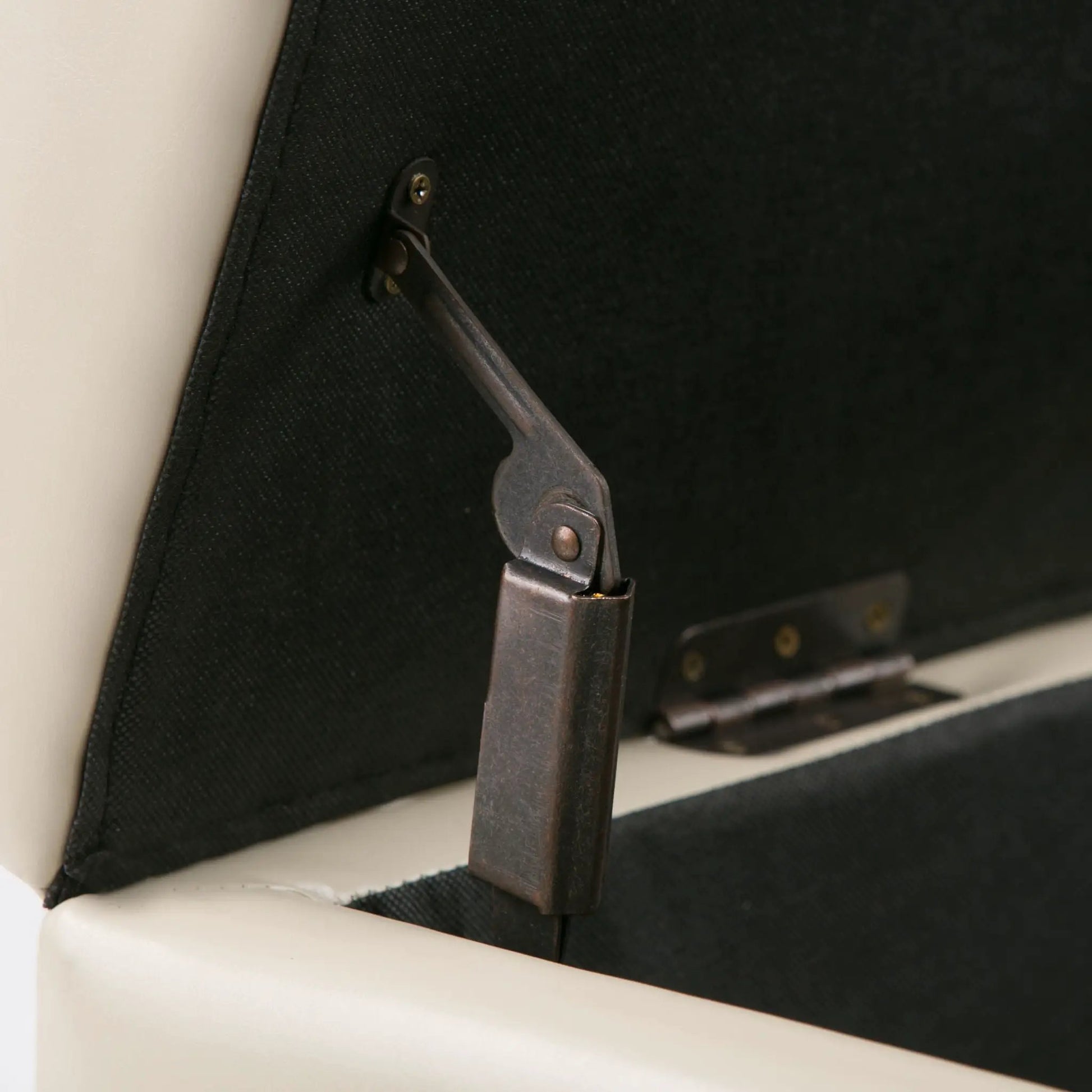 Avalon storage ottoman bench underside with brown metal hinge strap on black fabric on Tampa Home & Garden Store