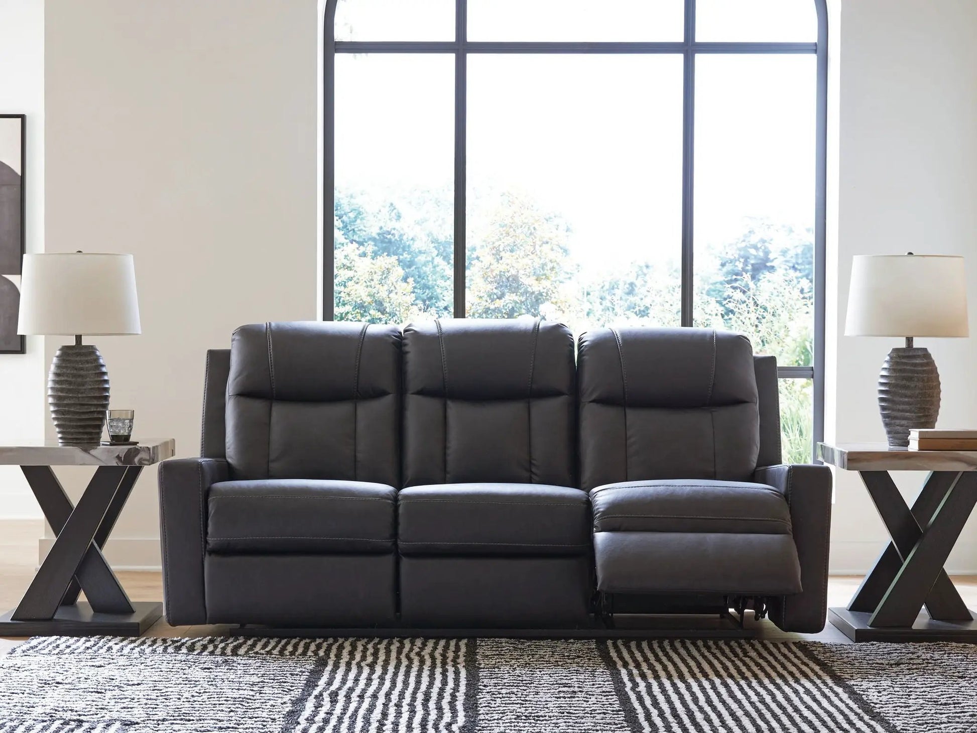 Mackmenville reclining sofa in dark leather by Unique Piece Furniture with end tables and lamps on Tampa Home & Garden Store