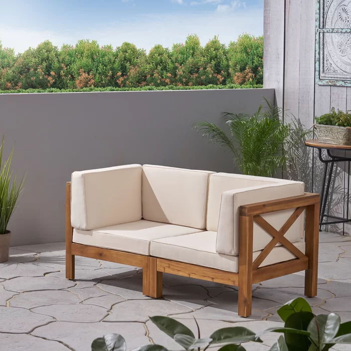 Brava X Back Loveseat with beige water-resistant cushions on a wooden outdoor frame on Tampa Home & Garden Store