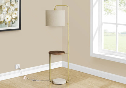 Brass floor lamp with beige fabric shade and small circular wooden shelf by a window on Tampa Home & Garden Store