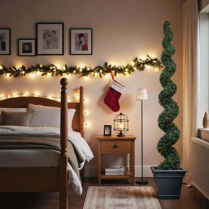 Tall spiral faux plant in square pot beside wooden nightstand with warm lights and stocking on Tampa Home & Garden Store