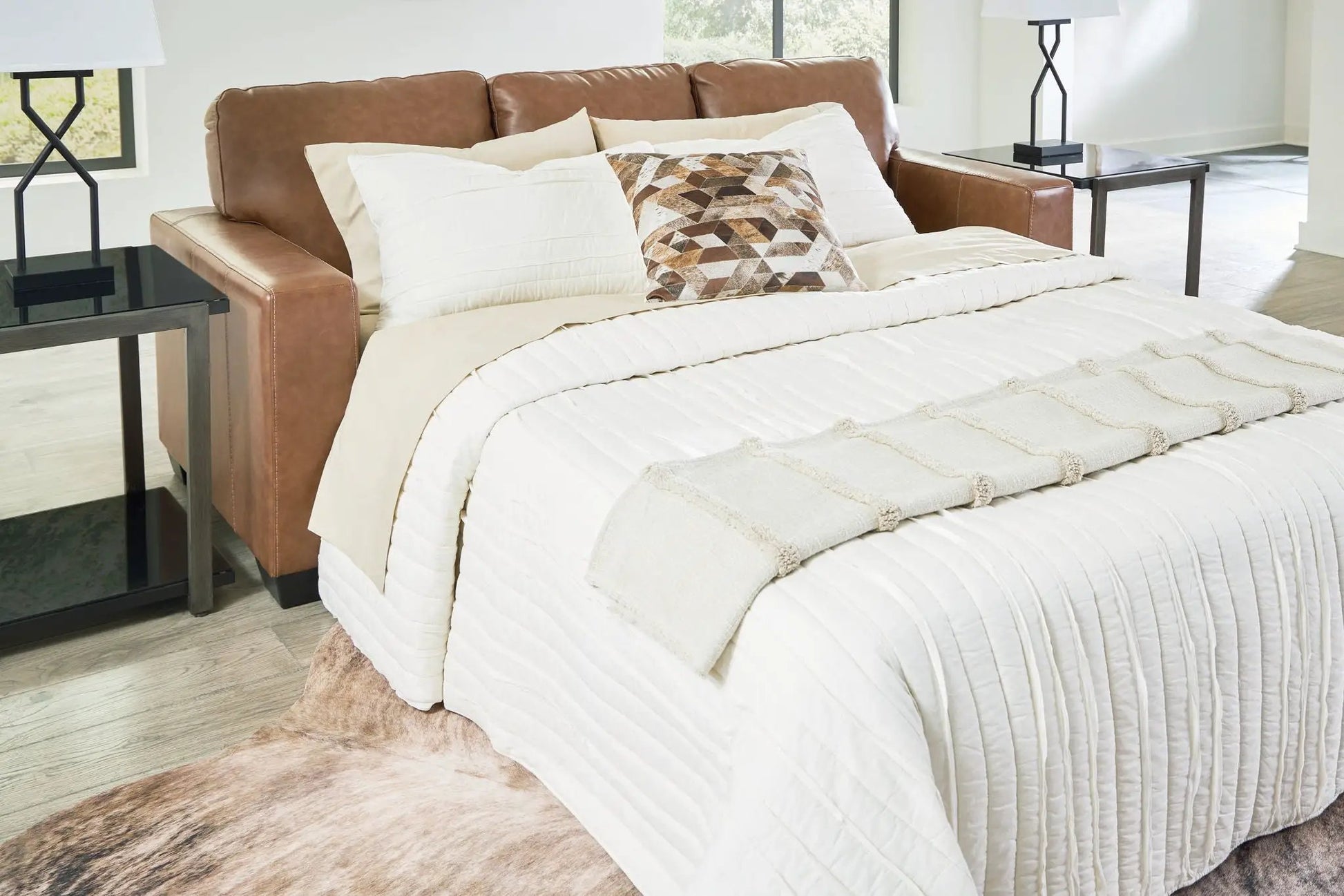 Bolsena Sofa Sleeper in tan leather with cream bedding and geometric pillow on Tampa Home & Garden Store