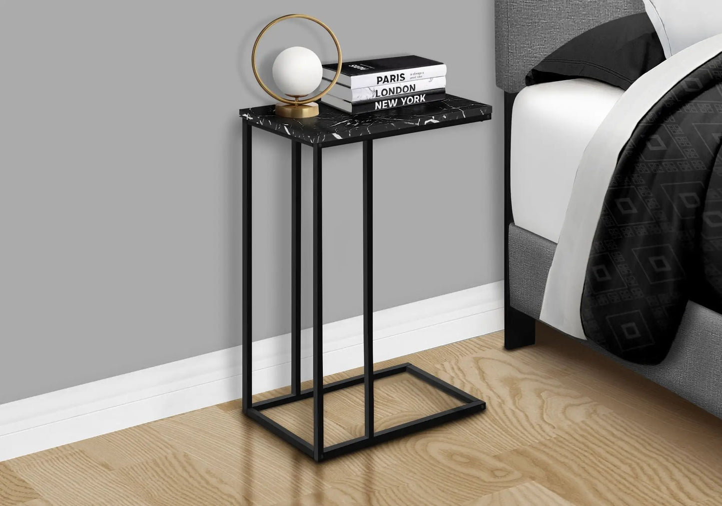 C-shaped accent table with black marble-look top and metal frame beside bed on Tampa Home & Garden Store