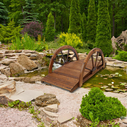 Wooden arc footbridge with half-wheel railings in brown finish over a rocky stream in lush garden on Tampa Home & Garden Store