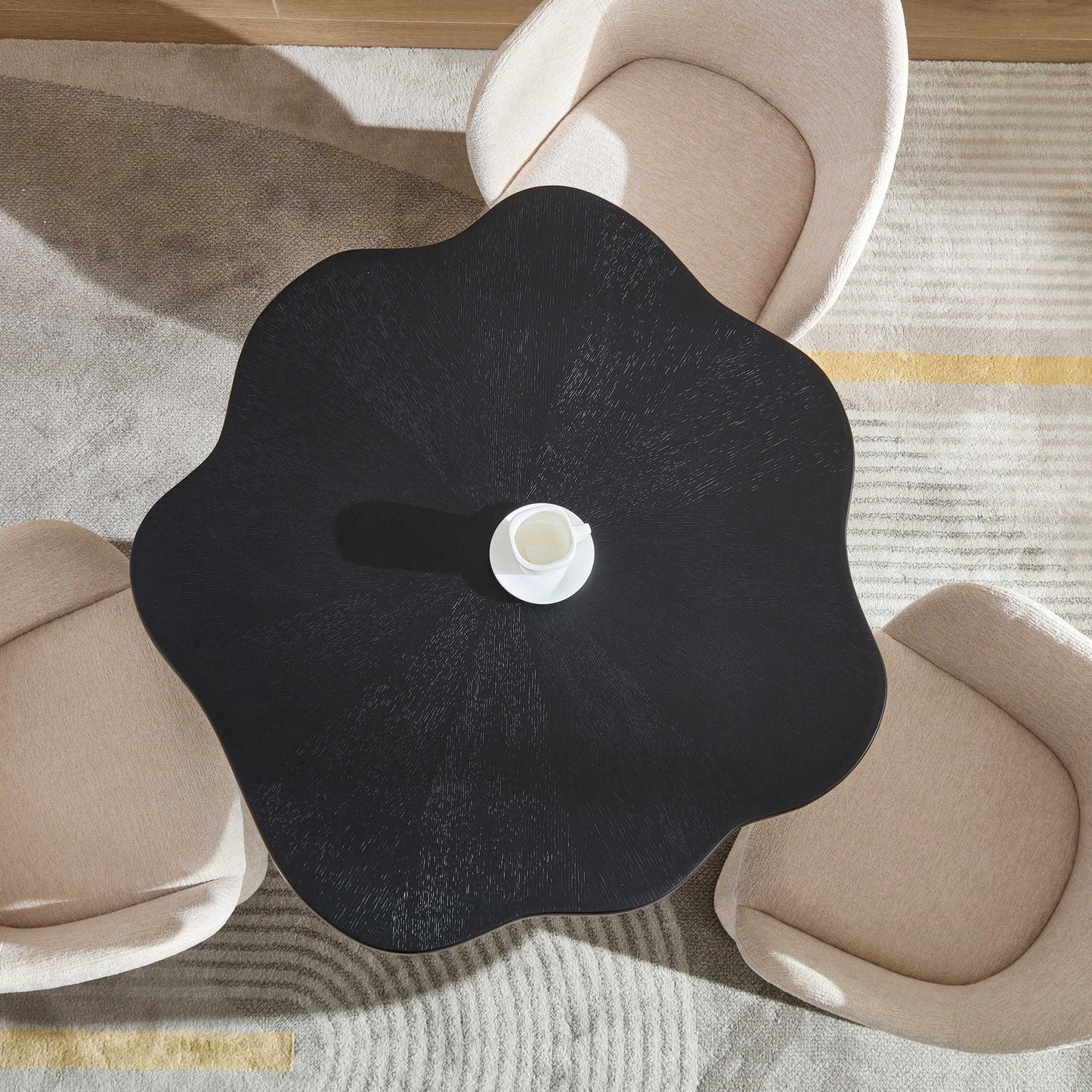 Sculptural round dining table with petal-shaped edge and root-textured black surface on Tampa Home & Garden Store
