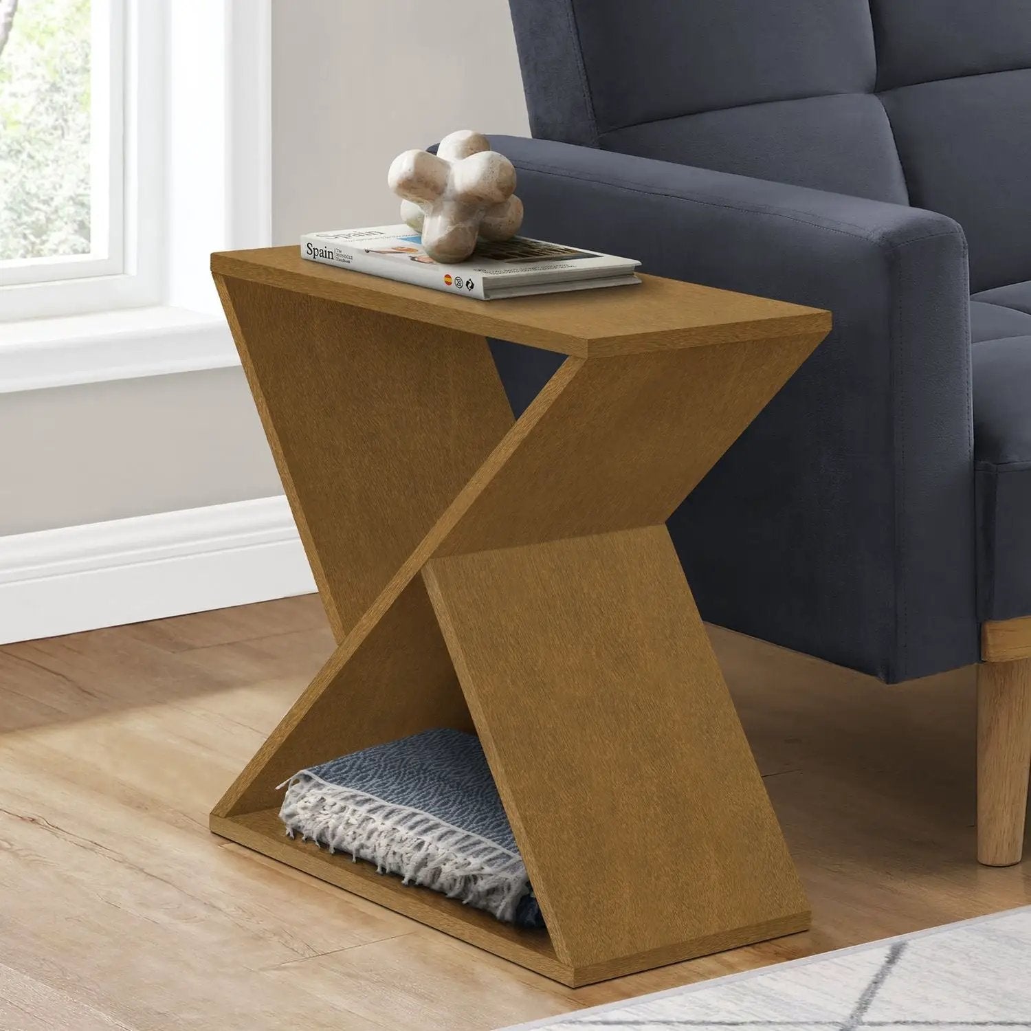 Accent Side Table in warm oak with geometric X-leg design, magazines beside a navy sofa on Tampa Home & Garden Store