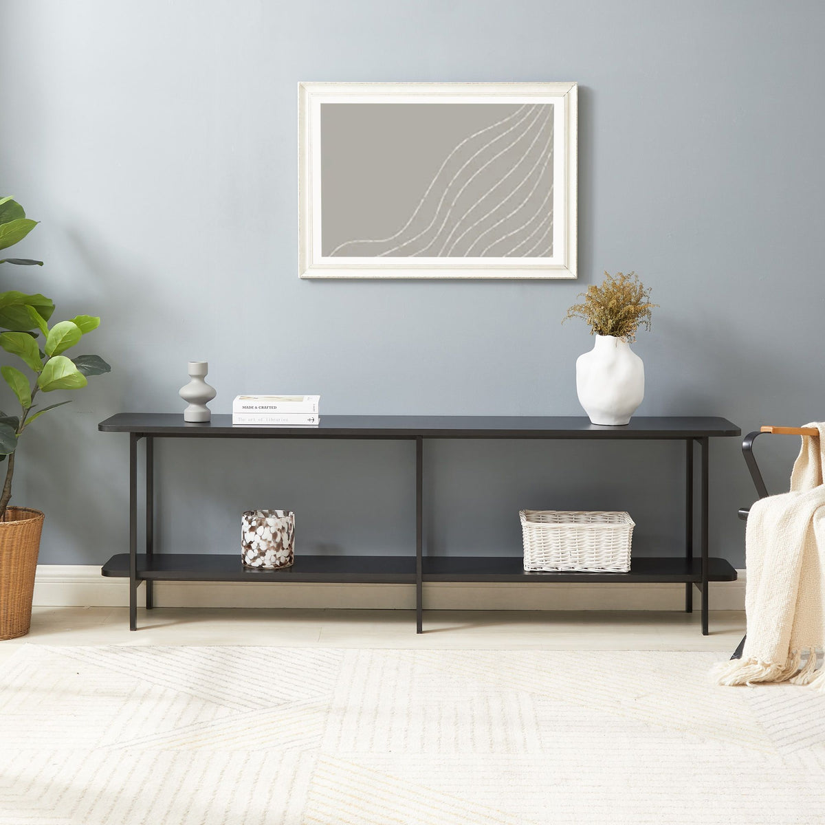 Celine 2-Shelf Console Table with black metal frame and two shelves set against a gray wall with a white vase and greenery on Tampa Home & Garden Store