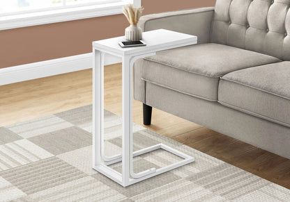 C-shaped modern accent table in white with vase and smartphone beside a gray tufted sofa on Tampa Home & Garden Store