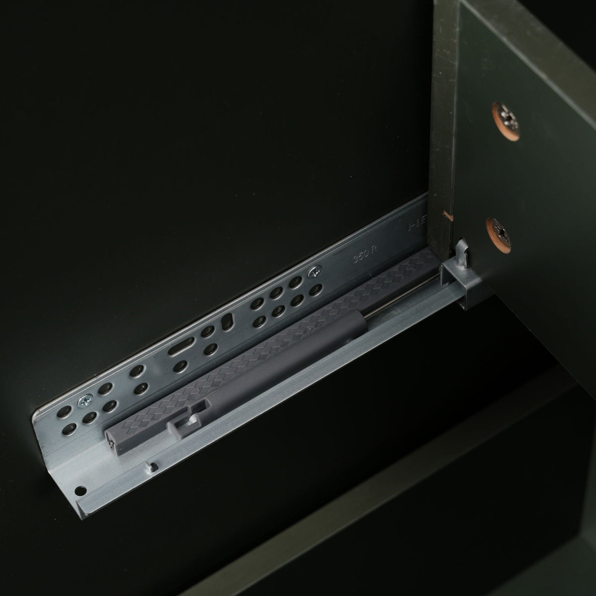 Bathroom vanity drawer rail inside dark green cabinet with metal track and copper hardware on Tampa Home & Garden Store
