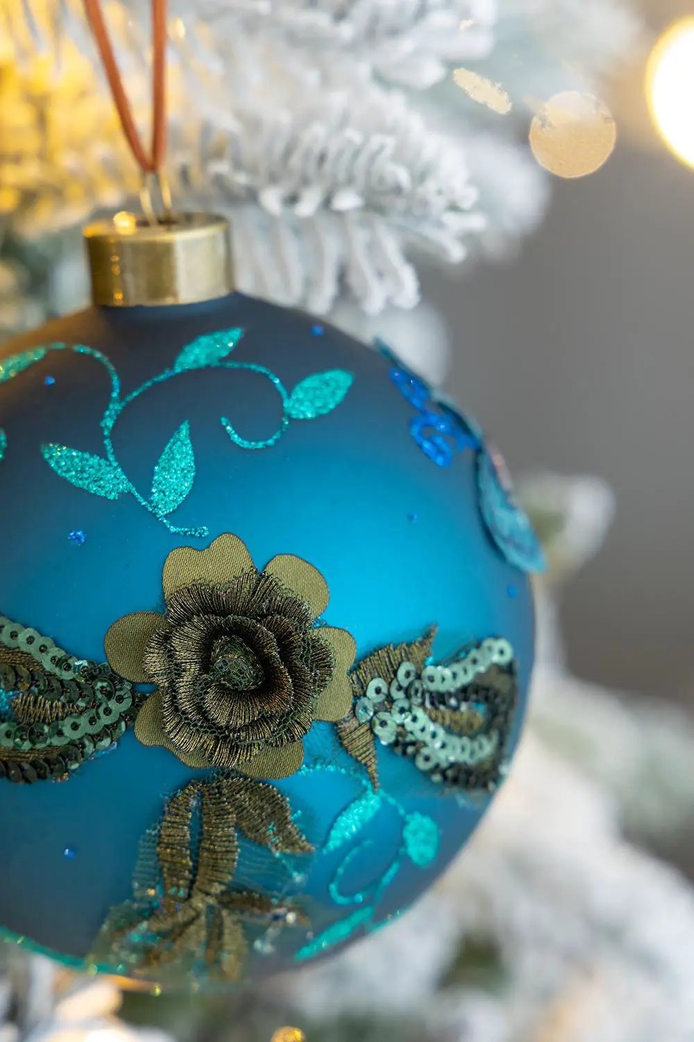 Blue glass Christmas ball ornament with gold flower embroidery and teal sequins on Tampa Home & Garden Store