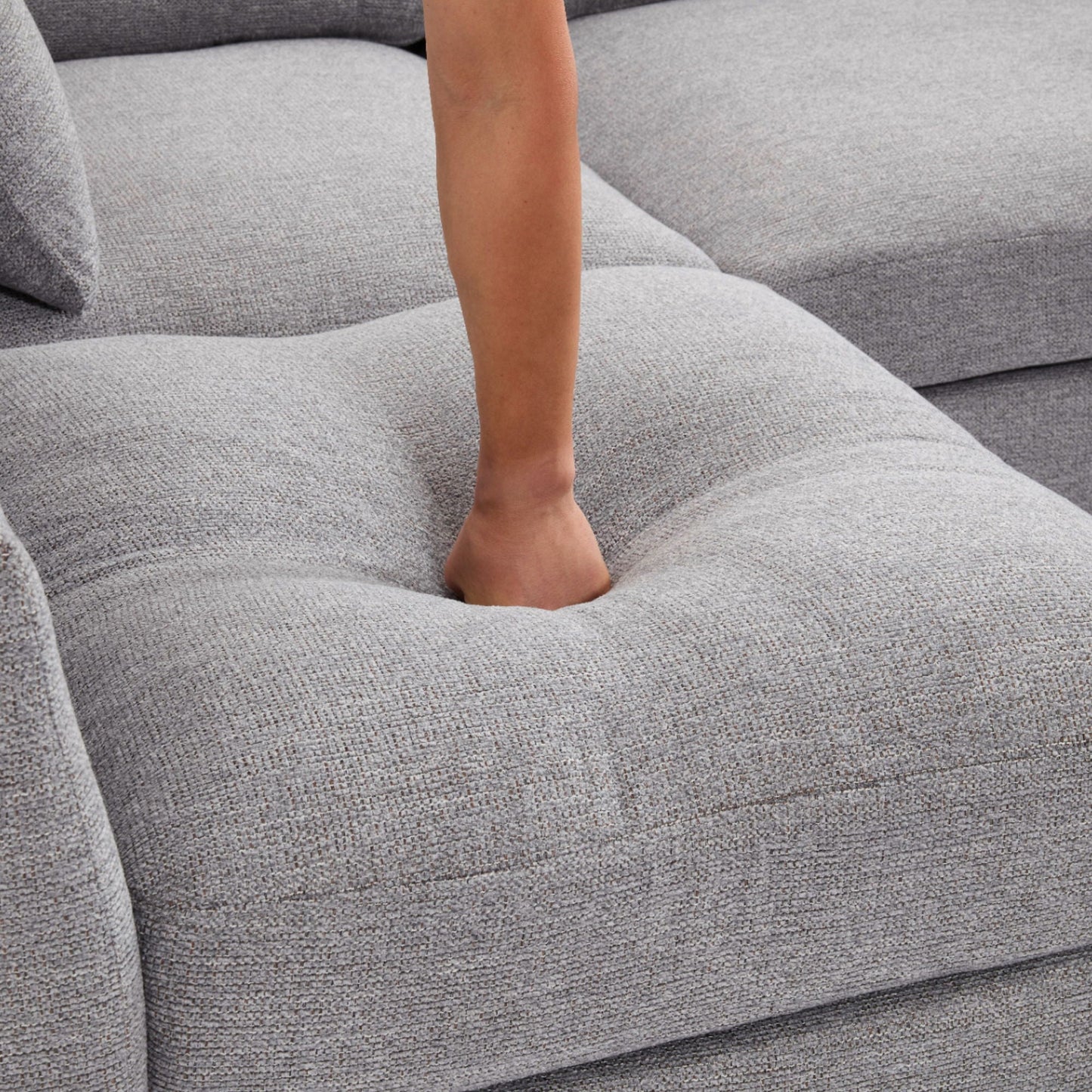 Sectional sofa gray textured fabric close-up with a forearm resting on cushion on Tampa Home & Garden Store