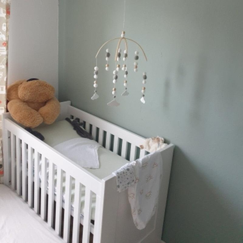 Stevvex crib mobile with Nordic wooden beads and wool balls, ivory-gray beads over white crib on Tampa Home & Garden Store
