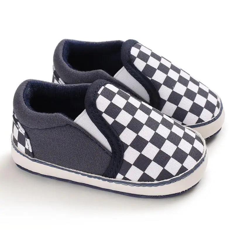 Pair of baby slip-on sneakers with navy canvas and black-white checkerboard pattern, soft sole on Tampa Home & Garden Store